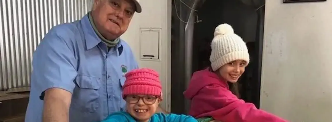 A man and two children wearing hats.